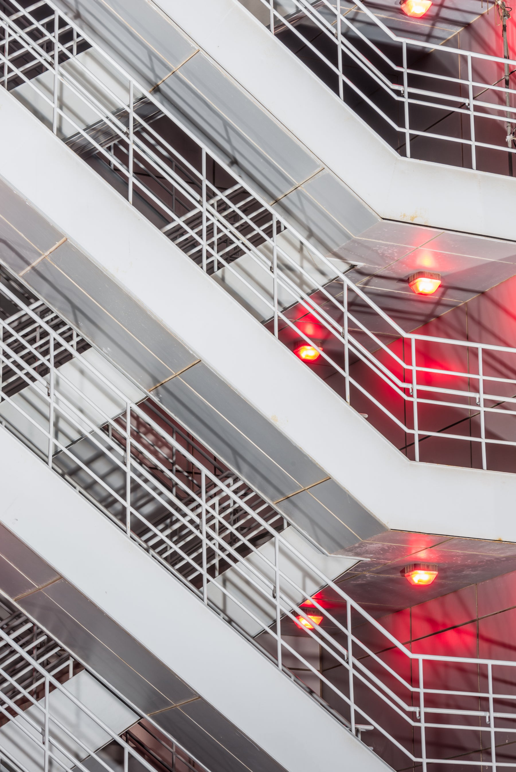 Modern architectural interior with white staircases and red lights.
